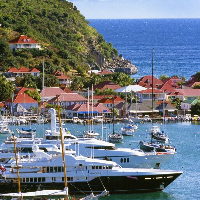 Plage paradisiaque de Saint-Barthélemy avec un yacht luxueux amarré au large.