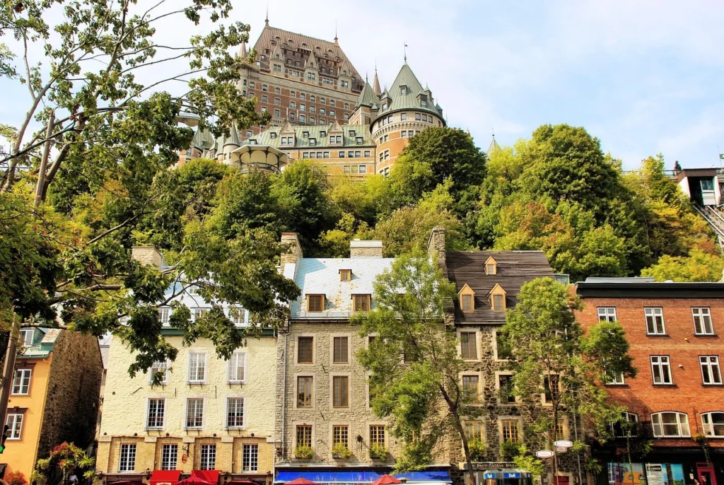 Le Château Frontenac au sommet de la colline, entouré de maisons historiques dans la vieille ville de Québec.