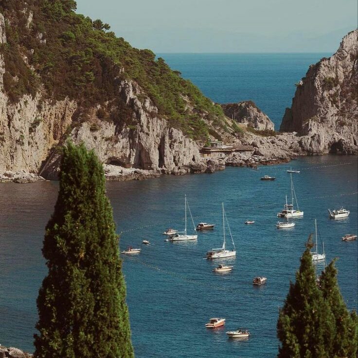 Vue panoramique sur Capri et ses falaises majestueuses plongeant dans la Méditerranée.