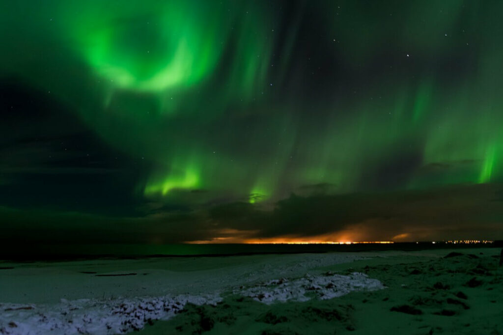 Spectacle naturel des aurores boréales en Islande, faisant partie du Top 5 des lieux à voir avant de mourir pour une expérience céleste unique.