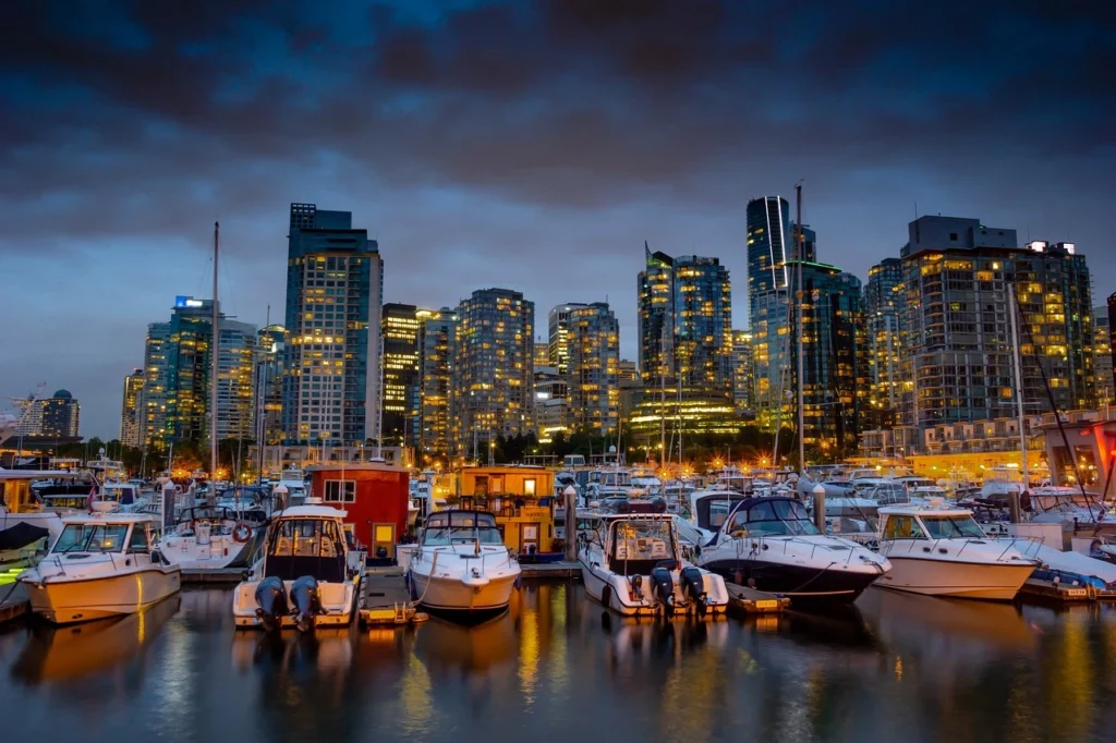 Vue de Granville Island à Vancouver avec des immeubles modernes et des montagnes au loin.