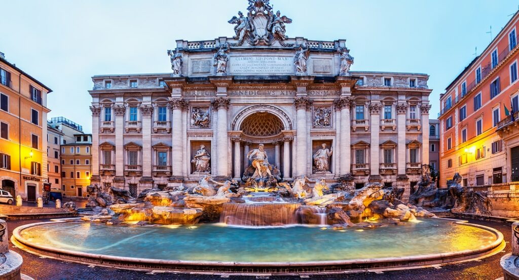 Photo de la Fontaine de Trevi de nuit éclairée par des lumières orangées 